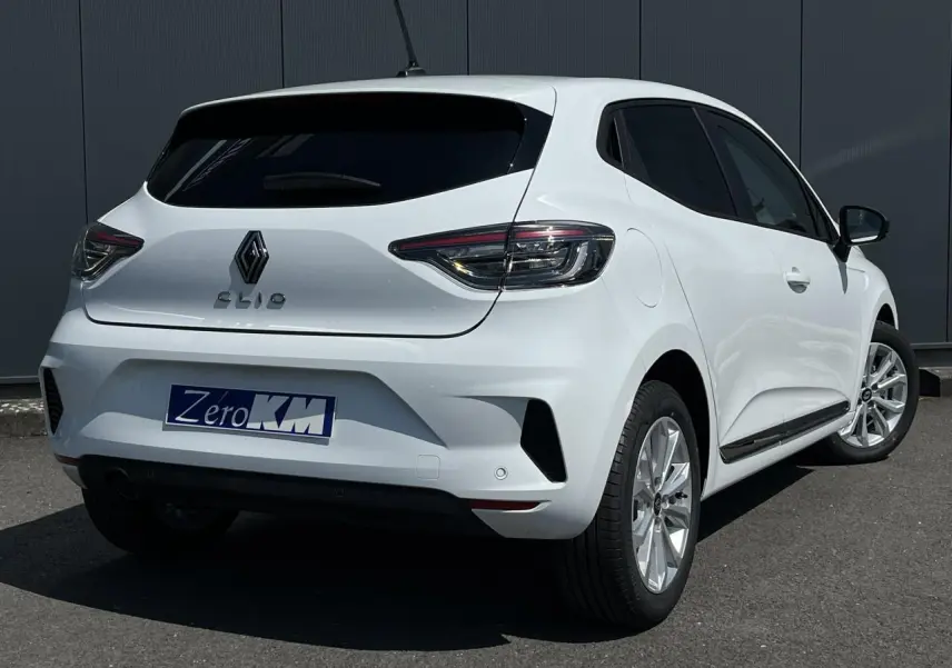 Renault Clio blanc glacier vue 3/4 arrière droit, vitres arrière surteintées et jantes 16'' Boavista visibles.