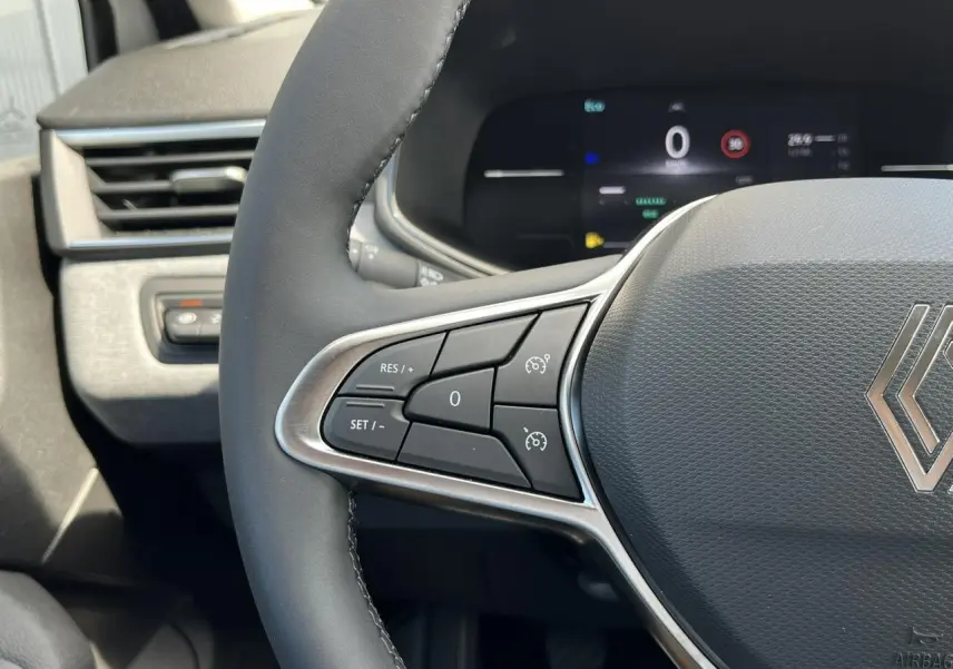 Gros plan sur le volant multifonction de la Renault Clio 2025, montrant les commandes de régulateur de vitesse.