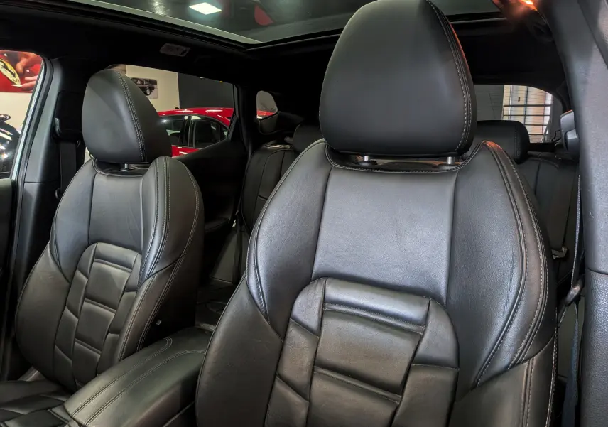 Gros plan sur les sièges avant en cuir noir du Nissan Qashqai 2018, intérieur spacieux avec toit panoramique.
