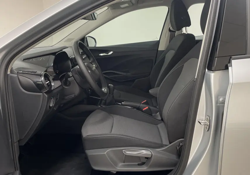 Intérieur côté conducteur d'une Skoda Fabia gris argent 2025, avec sièges tissu noir et tableau de bord moderne.