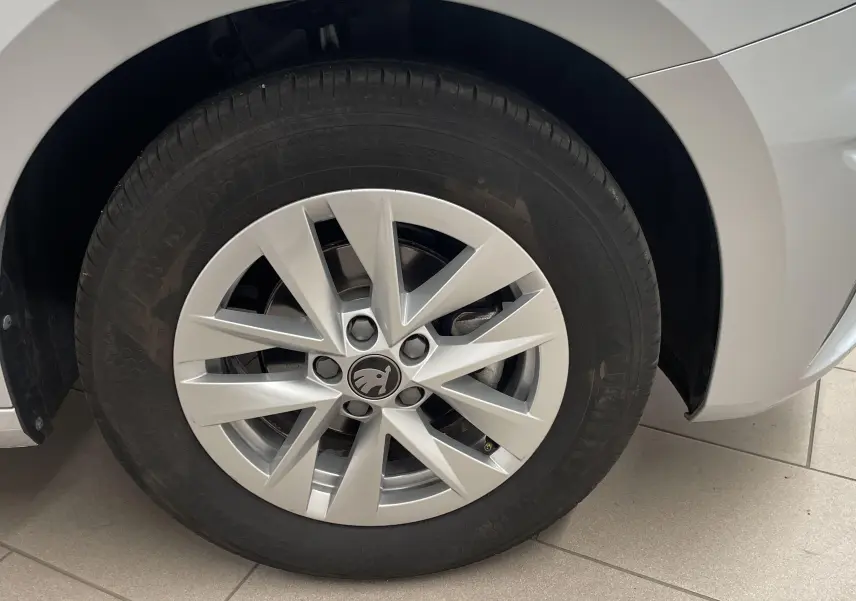 Gros plan sur la roue avant droite gris argent d'une Skoda Fabia 2025 avec jante alliage et logo central noir.