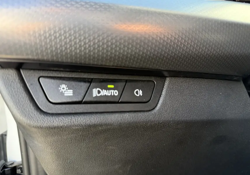 Gros plan sur les commandes d'éclairage intérieures noires du BMW X1 blanc Mineral, version 20D M Sport 2025.