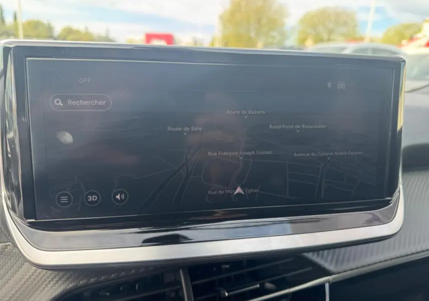 Écran tactile du système de navigation du Peugeot 2008 blanc, vue rapprochée de l'intérieur avec carte affichée.
