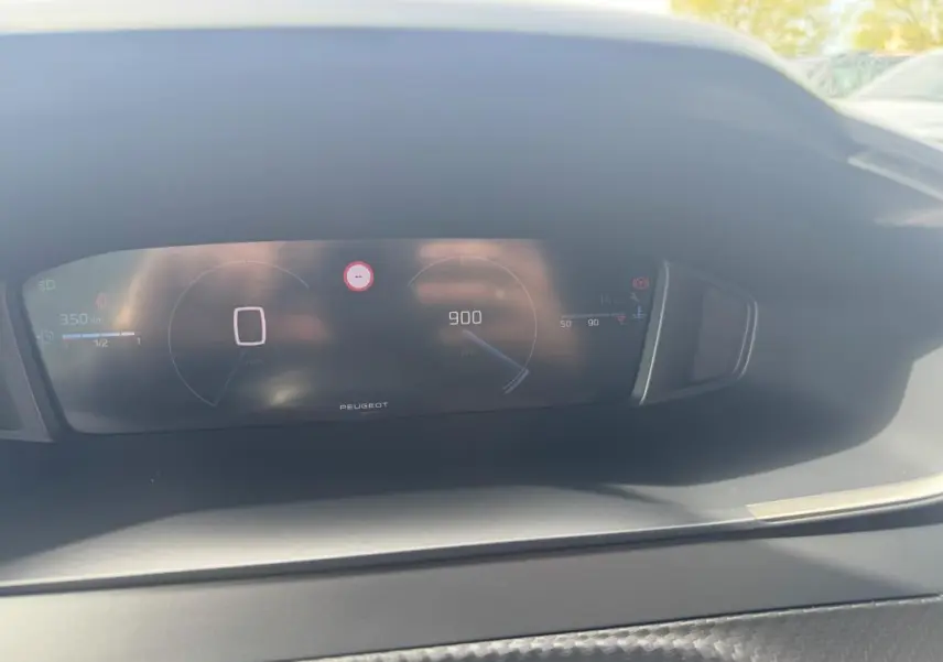 Vue rapprochée du cockpit numérique du Peugeot 2008 2024, affichant la vitesse à zéro et le compte-tours à 900 tr/min.