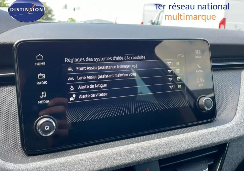 Écran tactile du tableau de bord de la Skoda Scala blanc glacier, affichant les aides à la conduite activées.