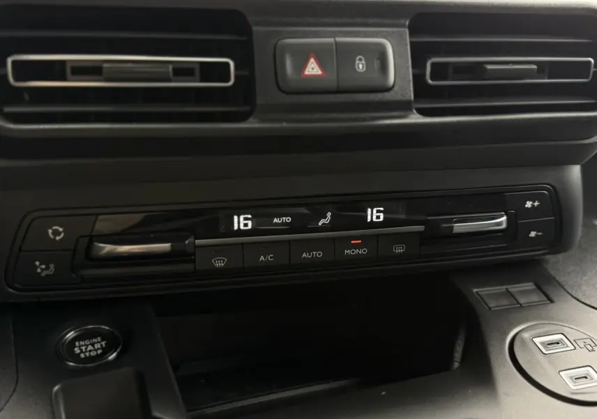 Détail du tableau de bord du Peugeot Rifter gris acier 2026, montrant la climatisation automatique bi-zone et bouton start/stop.
