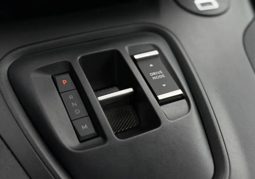 Gros plan sur la console centrale noire du Peugeot Rifter 2026 montrant les commandes de boîte auto et mode de conduite.