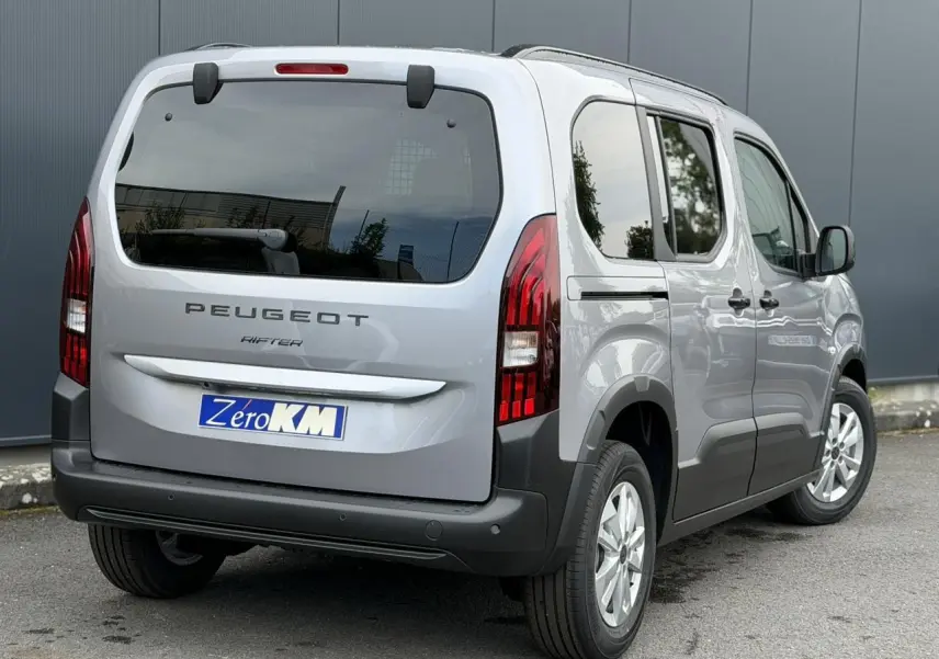 Vue 3/4 arrière droite du Peugeot Rifter gris acier 2026 avec portes coulissantes et feux arrière LED verticaux.