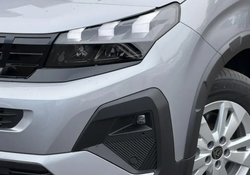Gros plan sur l’avant droit du Peugeot Rifter gris acier 2026, mettant en valeur le phare LED et la jante alu 16 pouces.