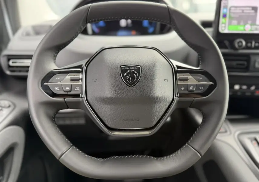 Volant cuir multifonction noir de Peugeot Rifter 2026, vue frontale centrée avec commandes intégrées et logo lion.