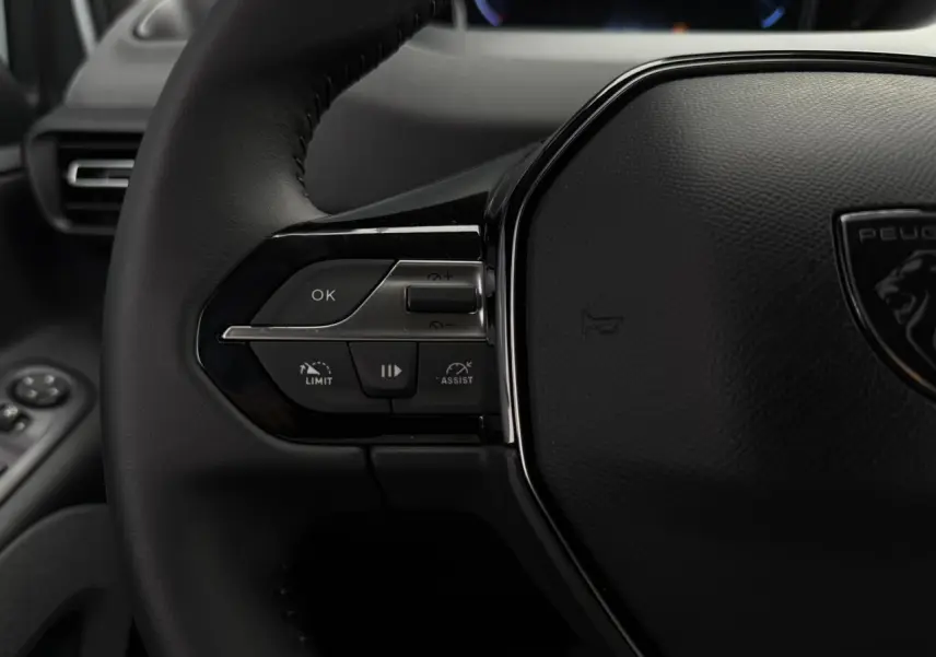 Gros plan sur le volant cuir multifonction du Peugeot Rifter 2026 avec commandes de régulateur et assistant de conduite.