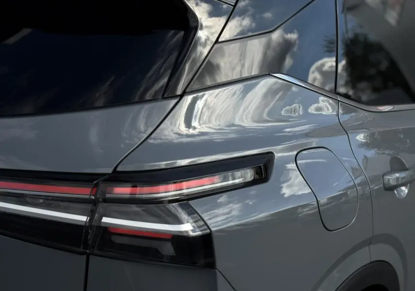Gros plan sur le feu arrière droit et la trappe à carburant du Nissan Qashqai gris Ceramic 2025, finition N-Connecta.