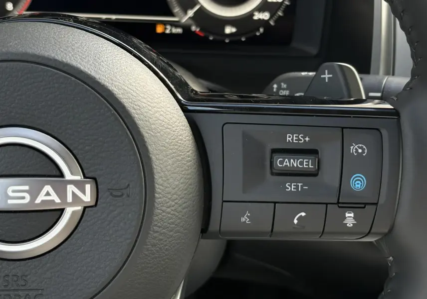 Gros plan sur le volant noir du Nissan Qashqai 2025, avec commandes de régulateur de vitesse et assistance active.