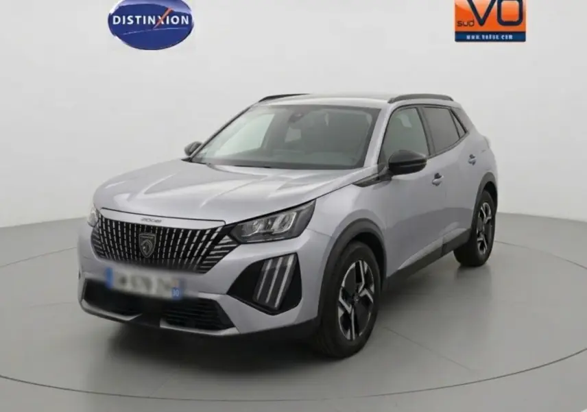 Peugeot 2008 Hybrid gris en 3/4 avant droit, avec barres de toit et jantes alliage 17 pouces visibles.