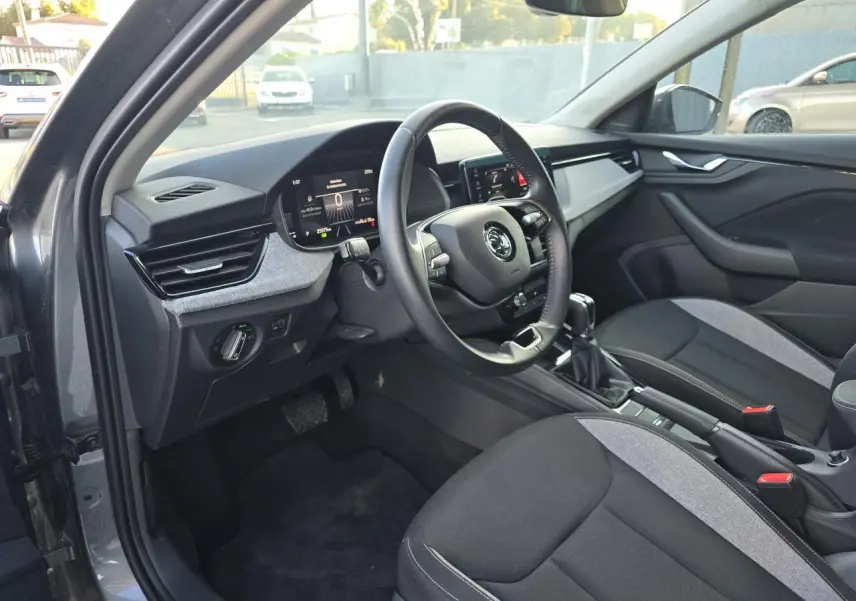 Intérieur avant droit de la Skoda Scala 2024 gris graphite, volant multifonctions et écran digital 8 pouces visible.