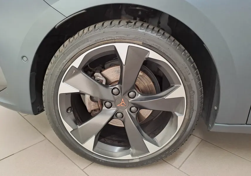 Gros plan sur la roue avant droite d'une CUPRA Leon 2024 gris magnétique mat avec jante en alliage distinctive.