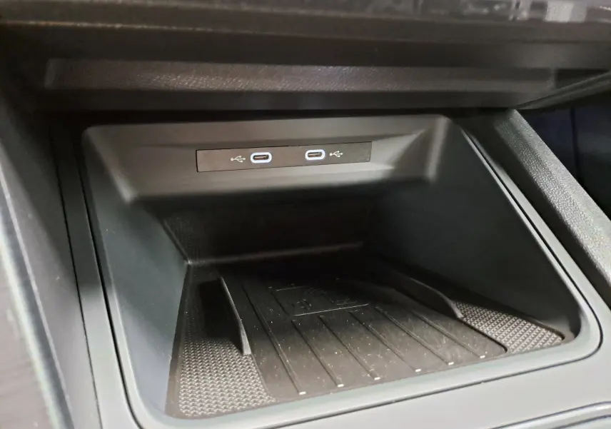Gros plan sur la console centrale du CUPRA Leon 2024 avec deux ports USB-C et un espace de rangement noir mat.