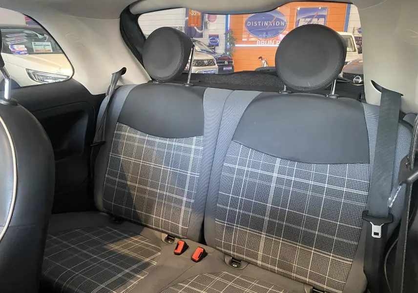Vue intérieure sur la banquette arrière de la Fiat 500 Lounge 2019 avec sièges en tissu à motif écossais noir et gris.