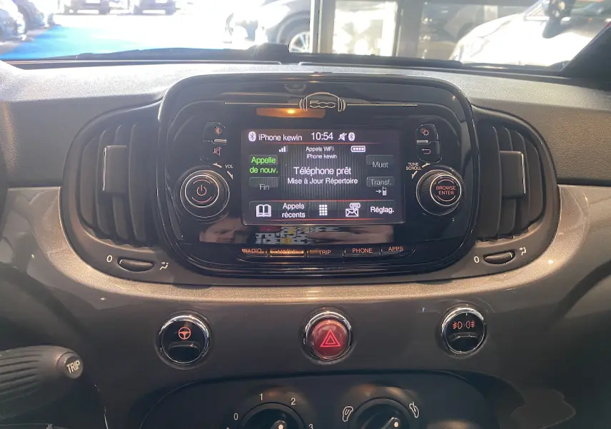 Vue rapprochée du tableau de bord noir de la Fiat 500 2019 avec écran tactile central et commandes circulaires.