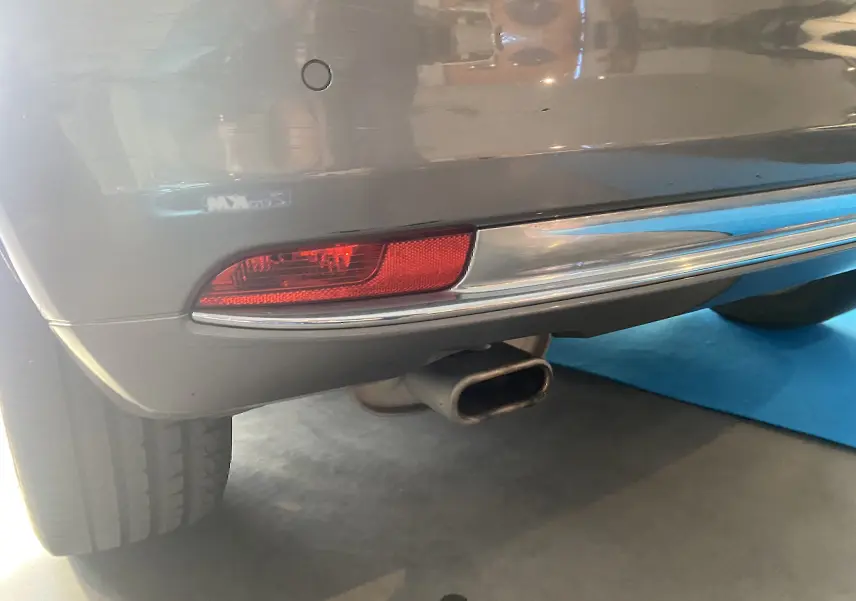 Gros plan sur le pare-chocs arrière gris foncé d'une Fiat 500 2019 avec feu rouge et sortie d'échappement rectangulaire.