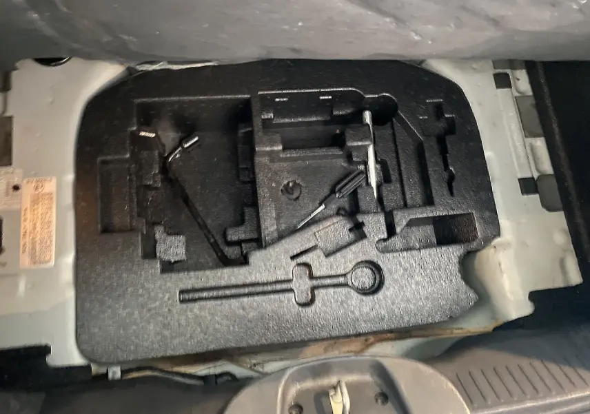 Coffre ouvert montrant le rangement à outils en mousse noire de la Fiat 500 gris foncé, version Lounge 2019.