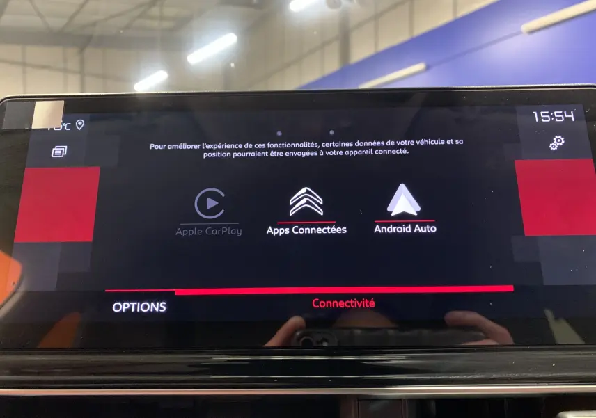 Vue rapprochée du tableau de bord noir du Citroën C5 Aircross hybride 2024, avec commandes tactiles et voyants rouges allumés.