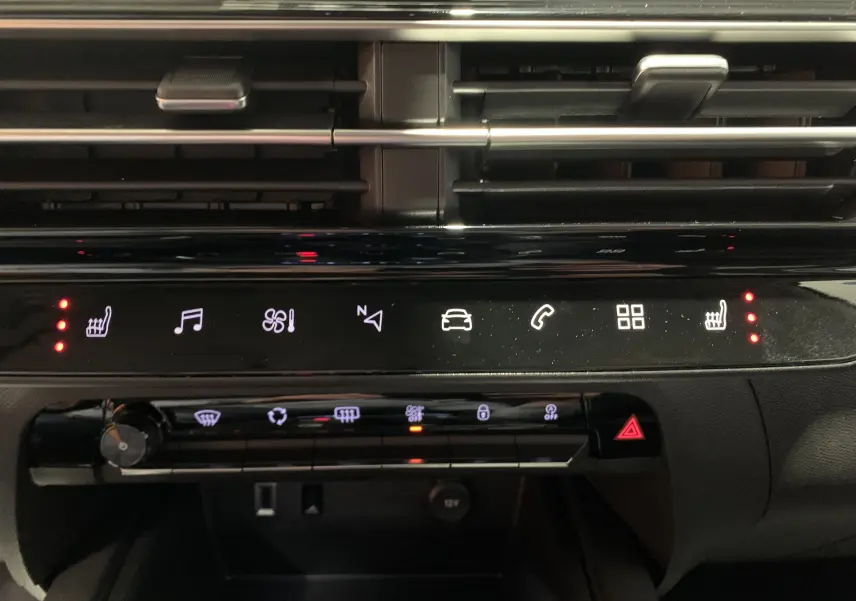 Gros plan sur la console centrale du Citroën C5 Aircross hybride 2024, montrant les commandes climatisation et prises USB.