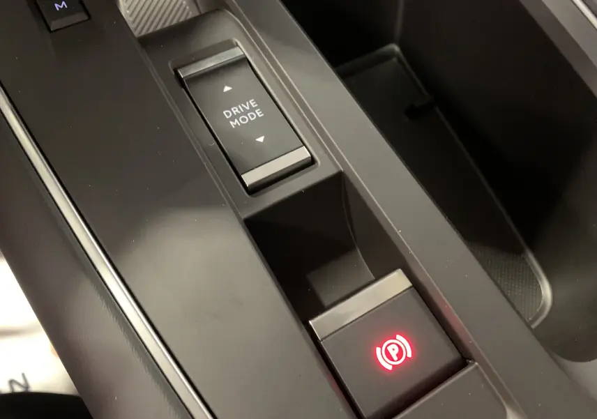 Gros plan sur l'accoudoir central noir et les porte-gobelets éclairés à LED dans l'habitacle du Citroën C5 Aircross hybride 2024.