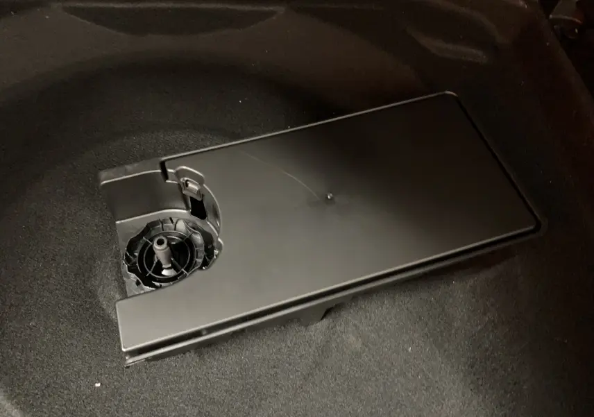 Détail du compartiment de rangement noir dans le coffre du Citroën C5 Aircross hybride blanc 2024.