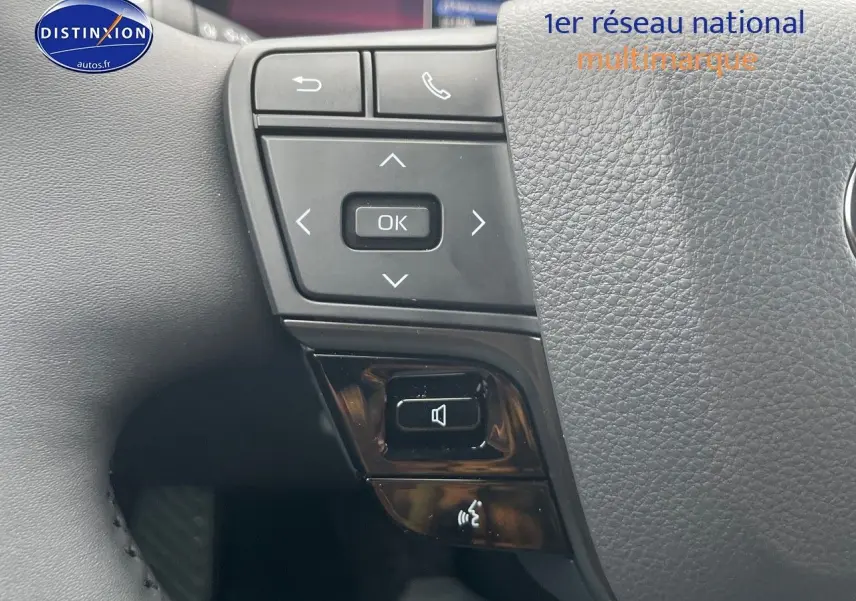 Gros plan sur les commandes au volant du Toyota C-HR 1.8 Hybrid 2024, finition Style, en cuir noir texturé.