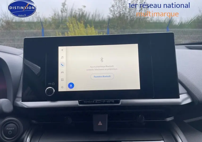 Écran tactile central allumé du Toyota C-HR 2024, vue frontale de la console intérieure avec commandes visibles.
