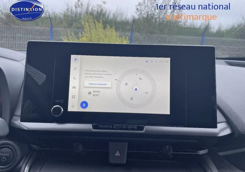 Écran tactile central du Toyota C-HR 2024 affichant une boussole, avec tableau de bord gris et volant partiel visible.