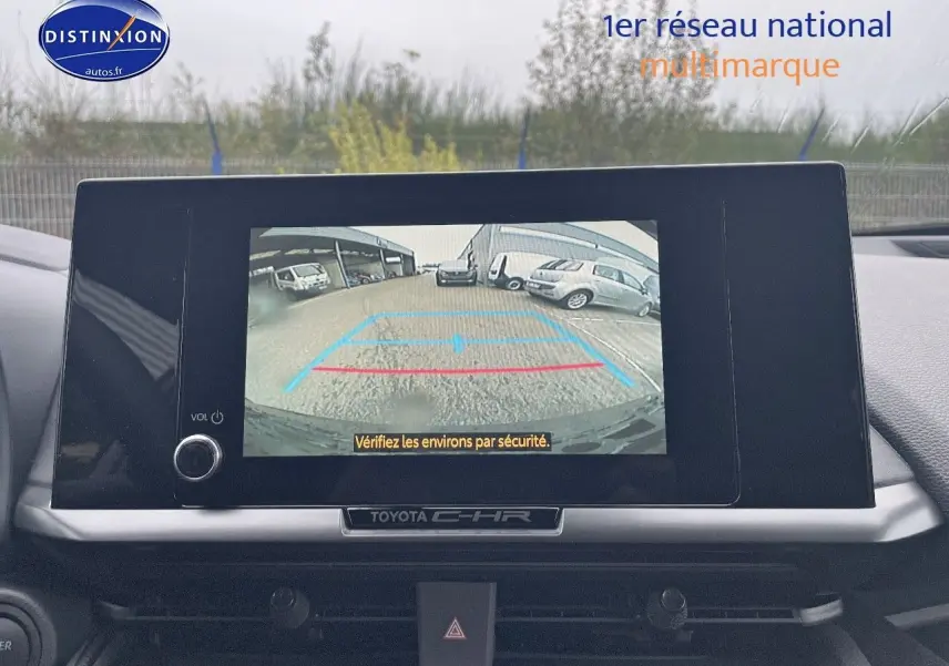 Écran central du Toyota C-HR 2024 affichant la caméra de recul avec vue sur un parking extérieur.