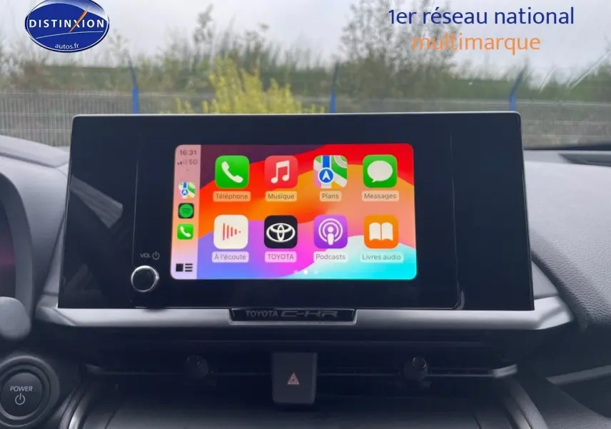 Écran tactile central allumé du Toyota C-HR 1.8 Hybrid 2024, vue intérieure du tableau de bord moderne.