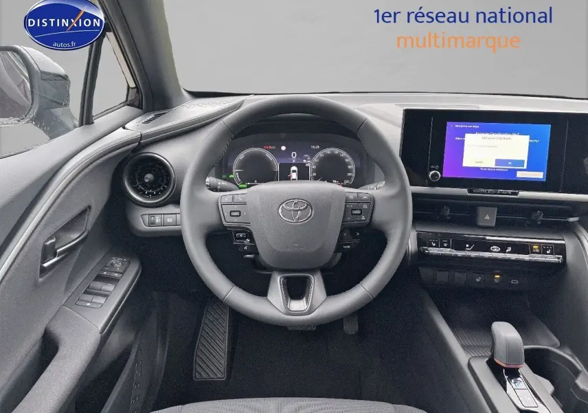 Vue frontale de l'habitacle du Toyota C-HR 1.8 Hybrid 2024 avec tableau de bord numérique et écran tactile central.