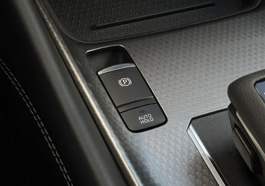 Gros plan sur la commande de frein à main électrique et fonction Auto Hold dans l’habitacle du Nissan Qashqai gris Ceramic 2025