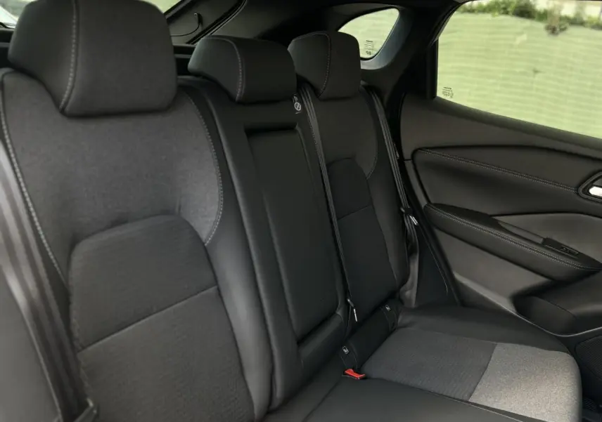 Banquette arrière en sellerie mixte noire du Nissan Qashqai 2025, vue côté droit avec appuie-têtes et ceinture de sécurité.