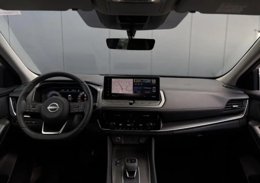 Tableau de bord et volant du Nissan Qashqai 2025 vus de face, avec écran tactile et finitions noires élégantes.