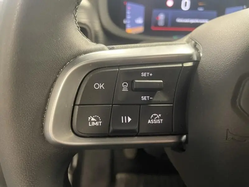 Gros plan sur les commandes au volant côté gauche du Jeep Avenger 2025, finition Altitude, avec boutons de régulateur et assistances.