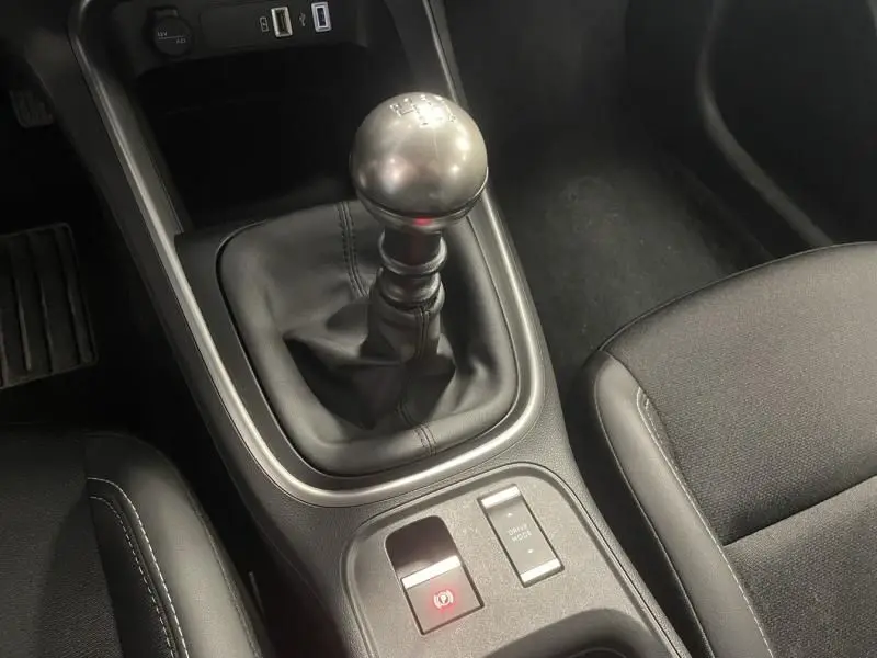 Gros plan sur la console centrale noire du Jeep Avenger 2025, mettant en valeur le levier de vitesse manuel et les commandes électroniques.