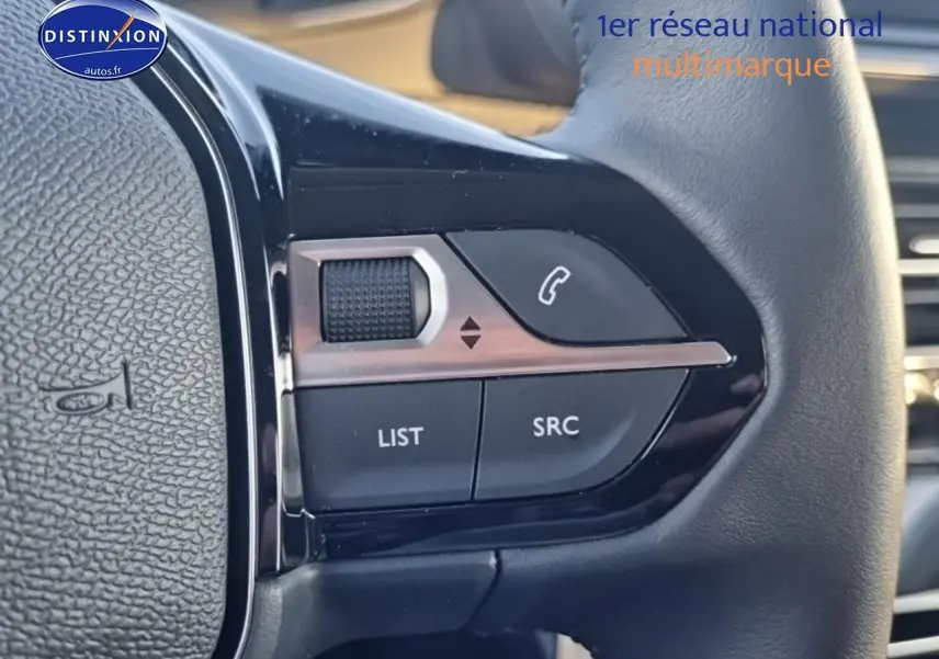 Gros plan sur les commandes audio au volant d’une Peugeot 208 gris Artense, version 1.2 100 allure 2025.