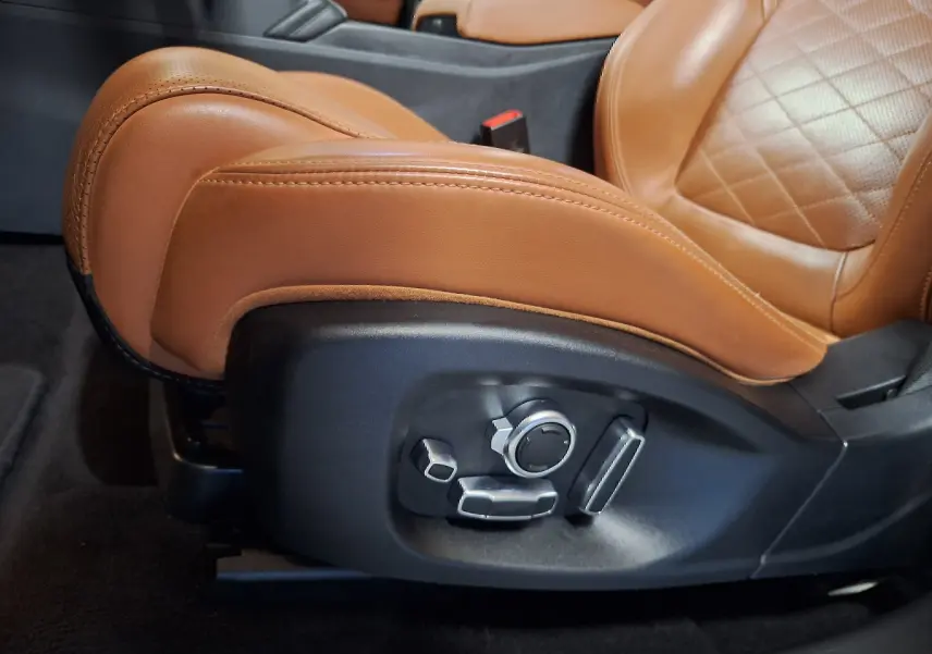 Détail du réglage électrique côté gauche du siège en cuir marron du Jaguar E-PACE blanc 2019.