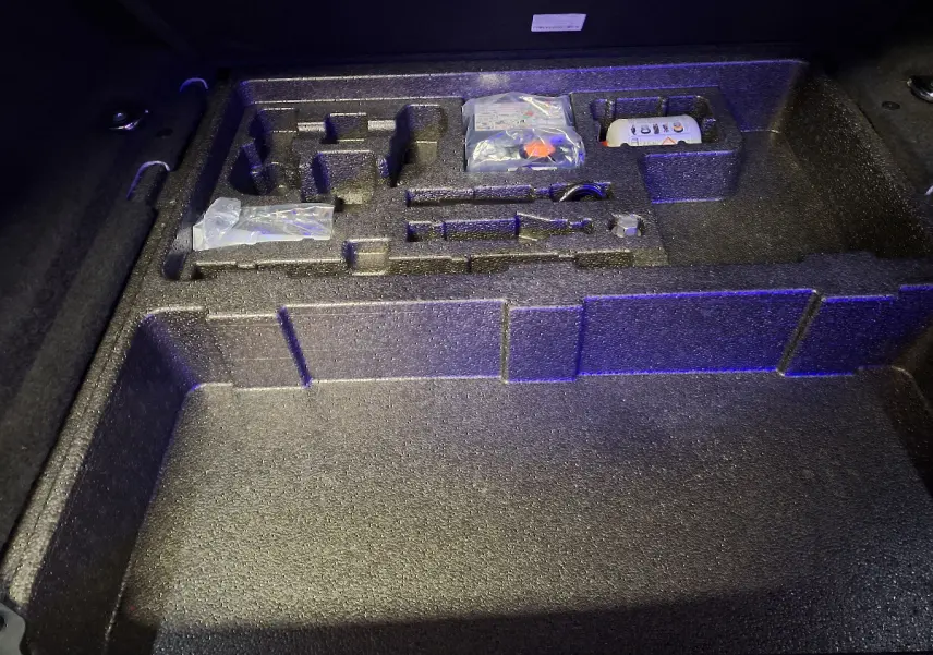 Rangement en mousse noire sous le coffre du Jaguar E-PACE 2019, compartiments pour outils et accessoires.