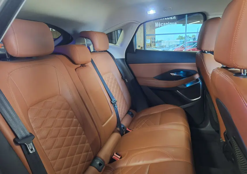 Vue intérieure arrière droite du Jaguar E-PACE 2019, sièges en cuir marron avec surpiqûres losanges et ceintures noires.
