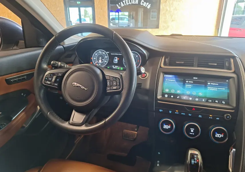 Intérieur Jaguar E-PACE 2019 vu côté conducteur, volant cuir, écran tactile 12,3 pouces et finitions marron cuir.