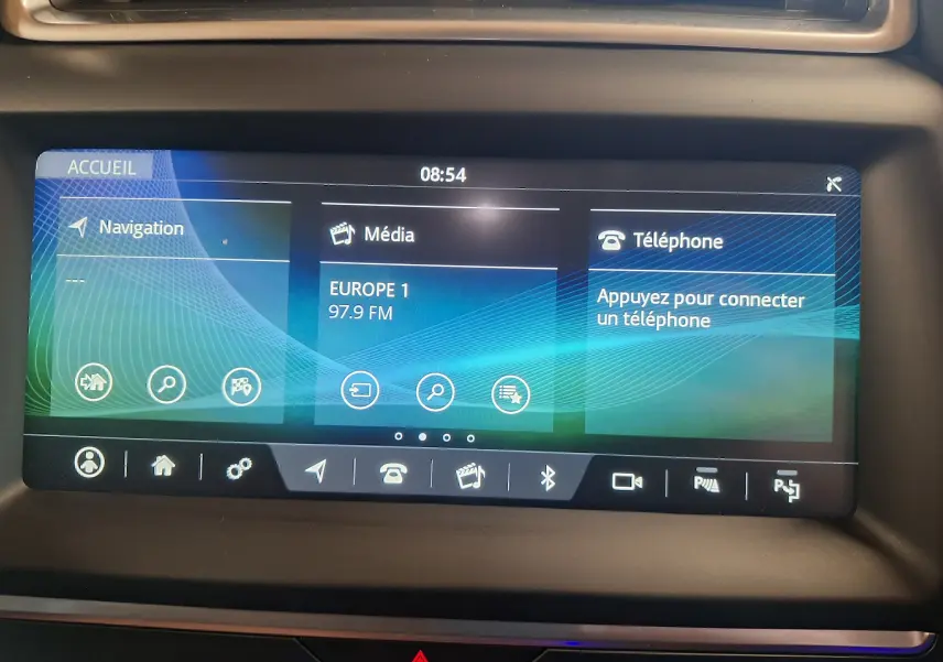 Écran tactile central du système de navigation et multimédia du Jaguar E-PACE blanc, affichant radio et téléphone.