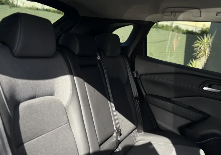 Vue du siège arrière côté droit du Nissan Qashqai gris Ceramic 2025 avec sellerie mixte tissu et TEP noire.