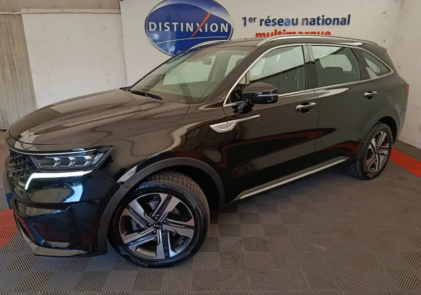 KIA Sorento noir hybride rechargeable vu en 3/4 avant droit, avec jantes alliage et feux LED allumés.
