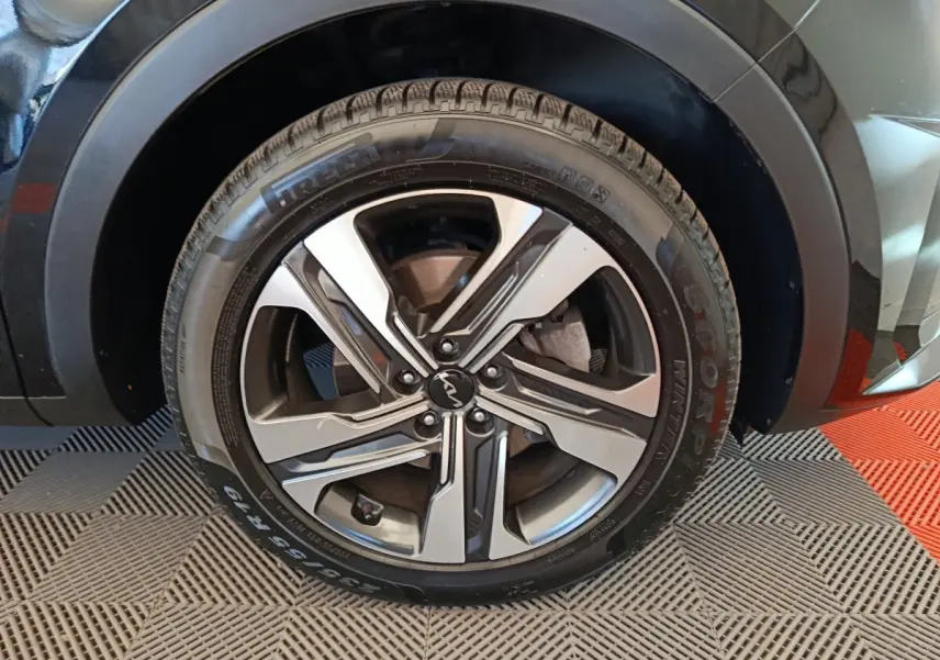 Gros plan sur la roue avant droite du KIA Sorento noir, avec jante alliage bicolore et logo central Kia.