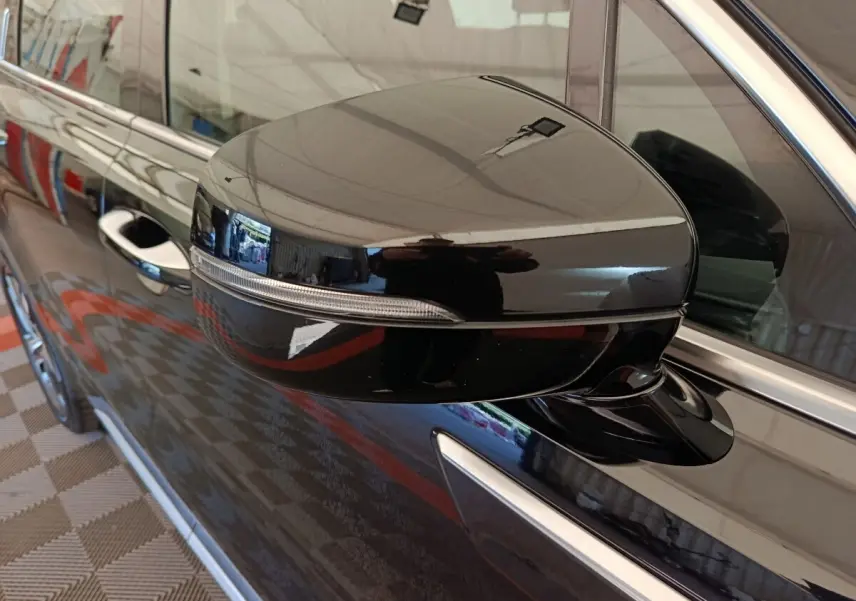 Rétroviseur droit noir brillant du KIA Sorento 2023 hybride rechargeable, avec clignotant intégré et poignée de porte visible.